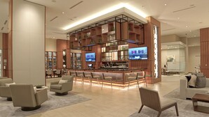 A modern lobby with a bar area, comfortable seating, and a large TV screen. - AC Hotel by Marriott Fort Lauderdale Airport (Dania Beach)