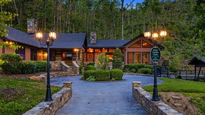 Un chalet à la façade en pierre, un chemin en pierre menant à l’entrée et un panneau indiquant « accès aux piétons uniquement ».