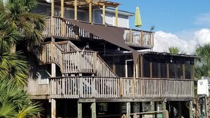 A multi-story wooden house with a balcony and a covered porch area. - Big Canal-front house, kayaks, canoes, game room, fish right from the dock. (Crawfordville)