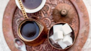A tray with a cup of coffee and sugar cubes.
