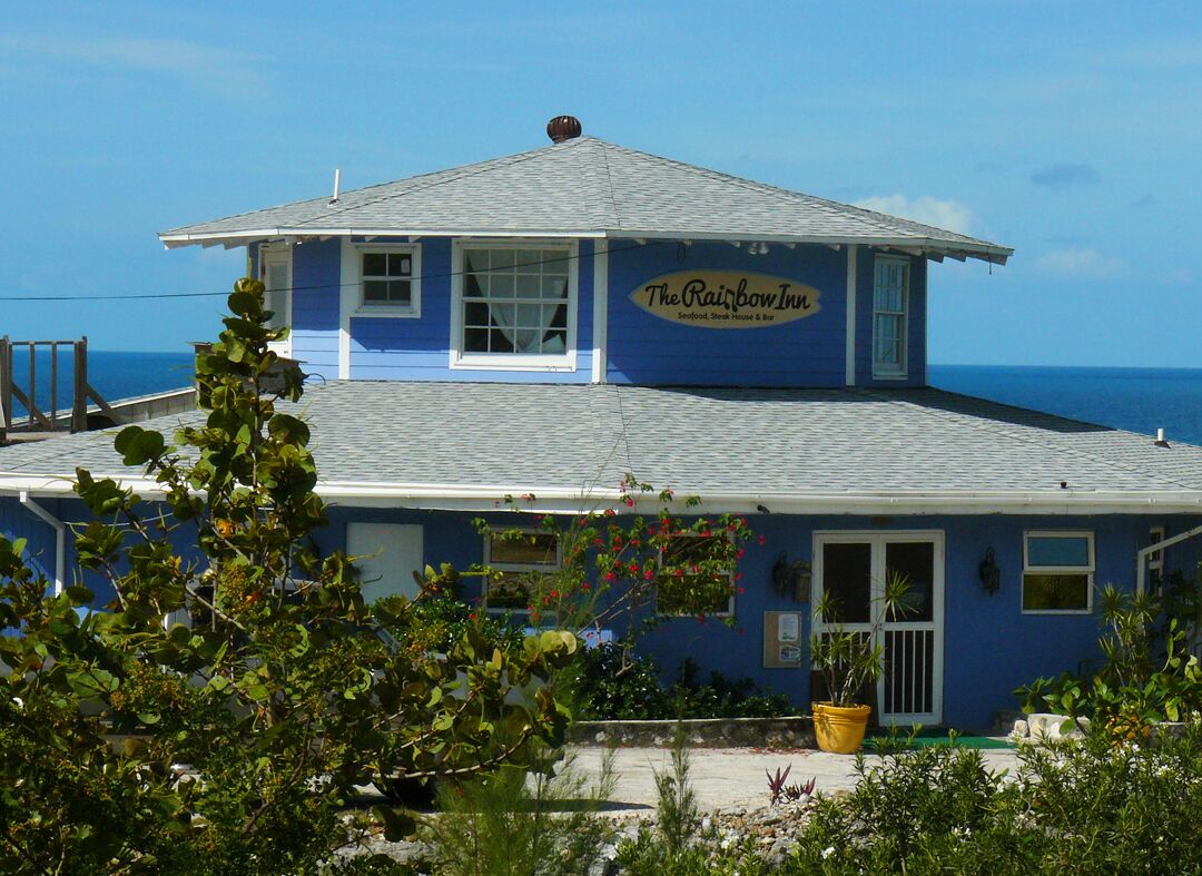 A two-story building with a blue exterior and a sign reading "The Rainbow Inn."