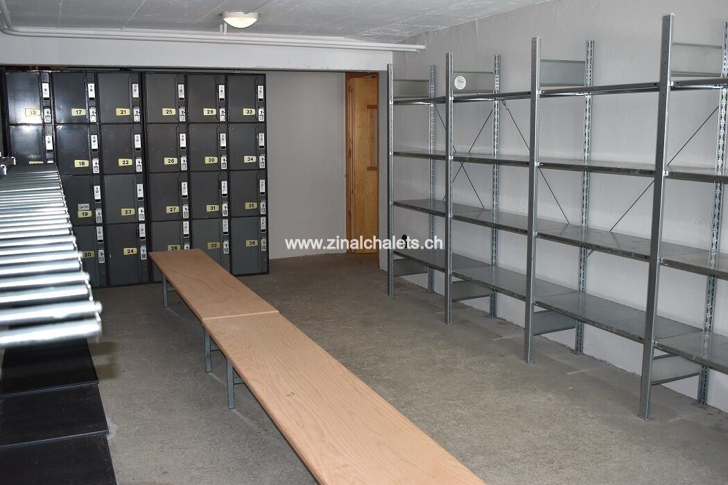 A storage room with metal shelving units, numbered storage boxes, and a wooden bench.