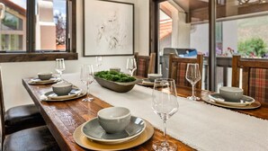 A dining area with a wooden table set for four, a bowl of green foliage, and a framed artwork on the wall. - NEW LISTING | 3BR Townhouse with AC, Pool, Golf, Tennis (Avon)