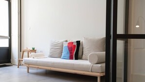 A minimalist room with a sofa, a small table, and a glass door.