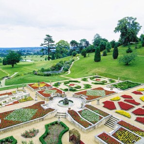 Stroll through the beautifully landscaped garden, featuring a central fountain and winding stone pathway.