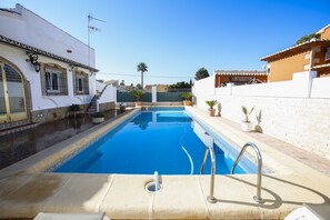 A swimming pool with a tiled edge, a metal handrail, and a small drainage hole. - 026 Villa Leonor (Denia)