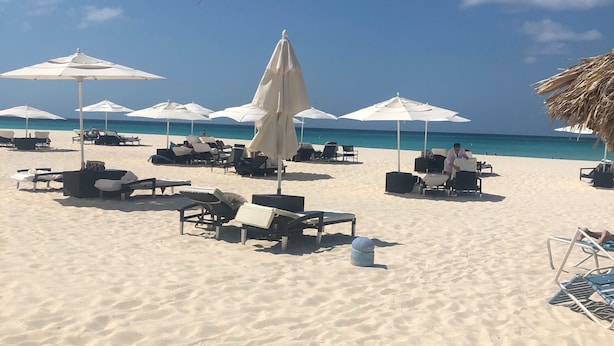 A beach with white umbrellas and lounge chairs. - ON EAGLE BEACH Costa Linda Beach Resort (oranjestad)