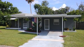 A two-story house with a covered porch, a front yard with a lawn, and a mailbox. - Mid Century Charm! KSC,Port Canaveral,Cocoa and Bio-Lume Kayak,Pet Friendly! (Titusville)