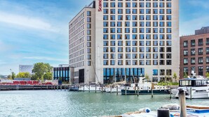 A modern hotel with a prominent Scandic sign, waterfront location, and docked boats. - Scandic CPH Strandpark (Kastrup)