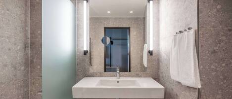 A modern bathroom with a rectangular sink, a mirror, and a towel rack.