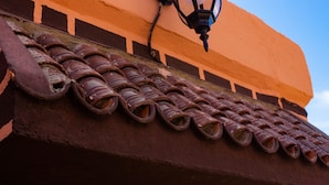 Un primo piano di un tetto in terracotta con un motivo a tegole tradizionale.