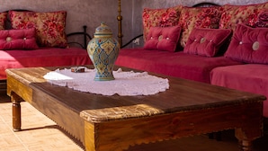 Una stanza accogliente con un tavolino in legno, un vaso decorativo e un candelabro.