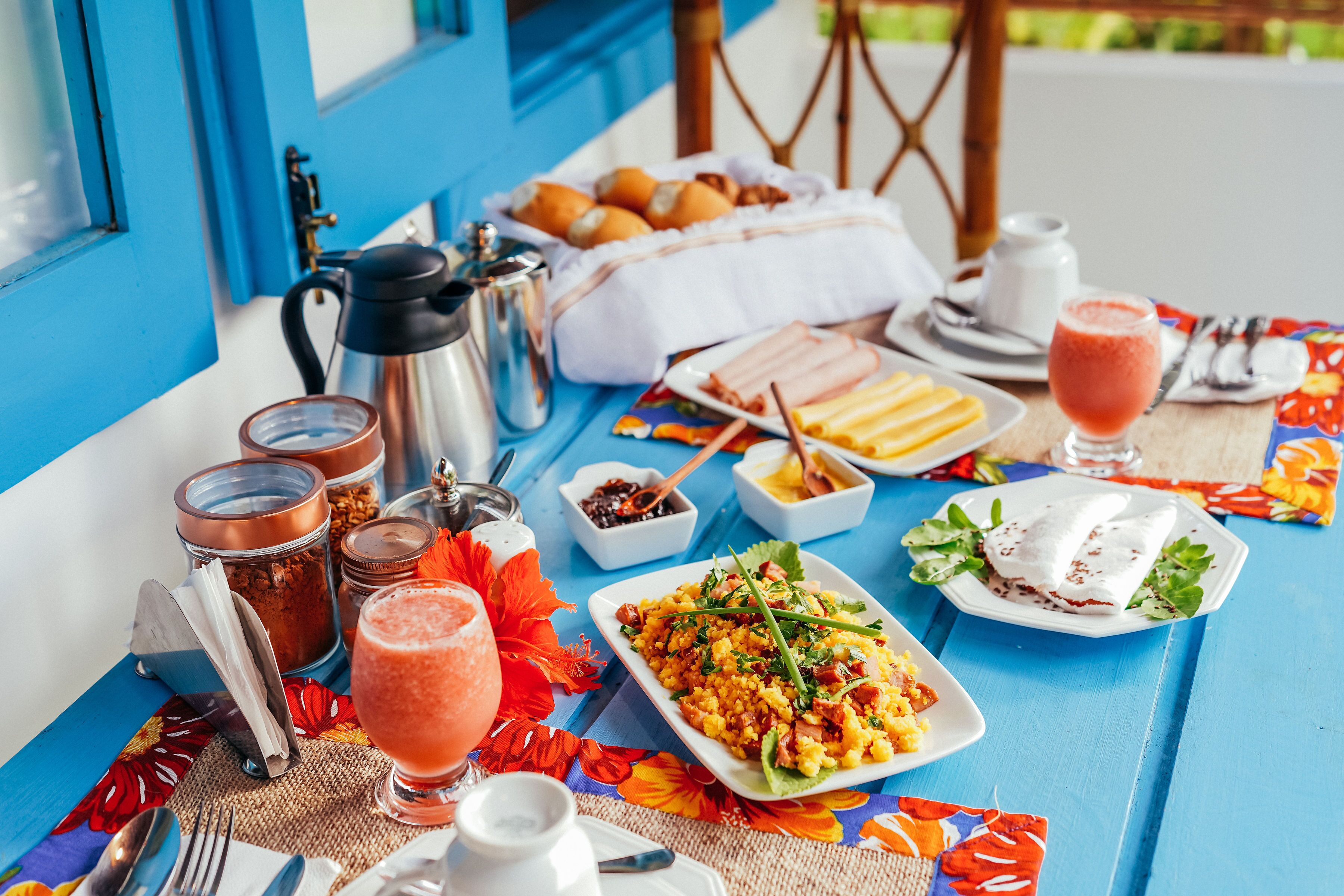 Een gedekte tafel met een maaltijd, inclusief een bord eten, een drankje en diverse toevoegingen.