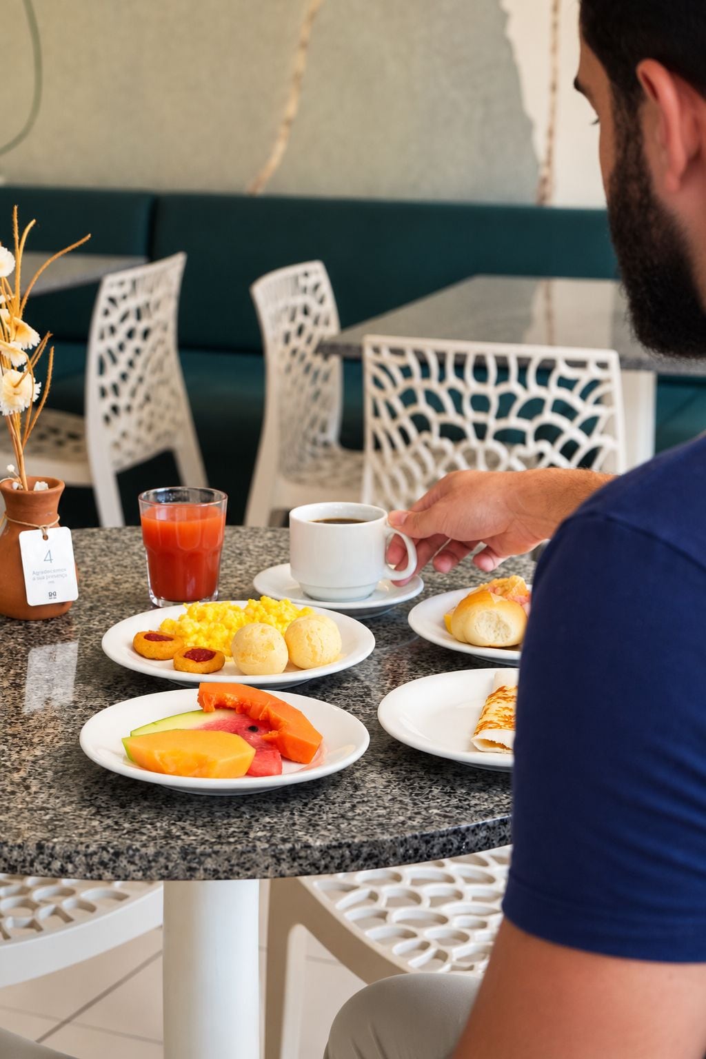 A breakfast setting with plates of food, a coffee cup, and a glass of juice on a table.