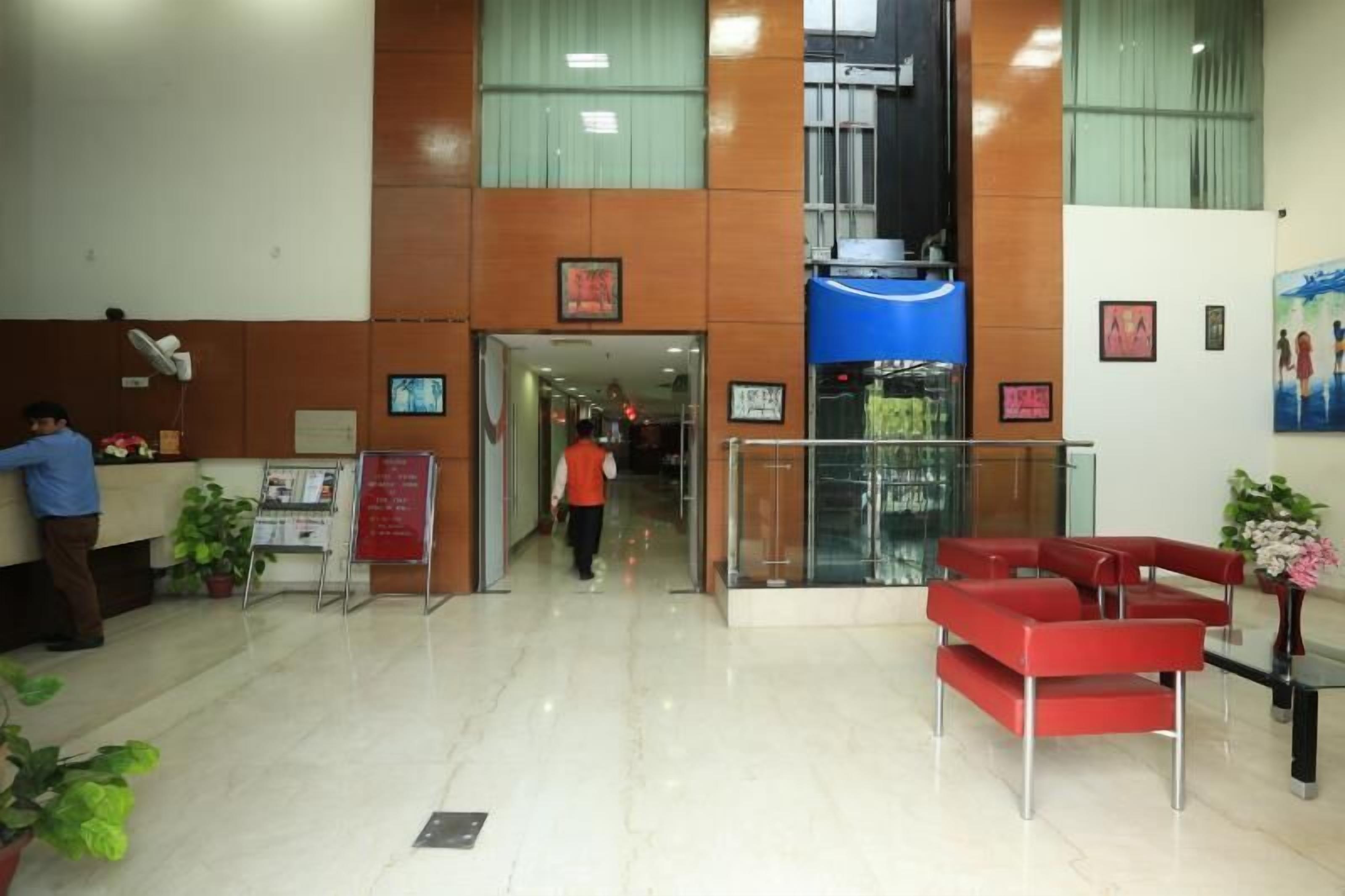 A reception area with a counter, chairs, and a staircase leading to an upper floor.