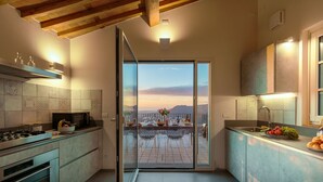 Une cuisine moderne dotée d’une porte-fenêtre coulissante qui donne sur un balcon offrant une vue panoramique.