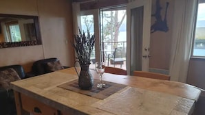 Une cuisine dotée d’un grand îlot central, d’une plante en pot et d’un verre d’eau posé sur le comptoir.