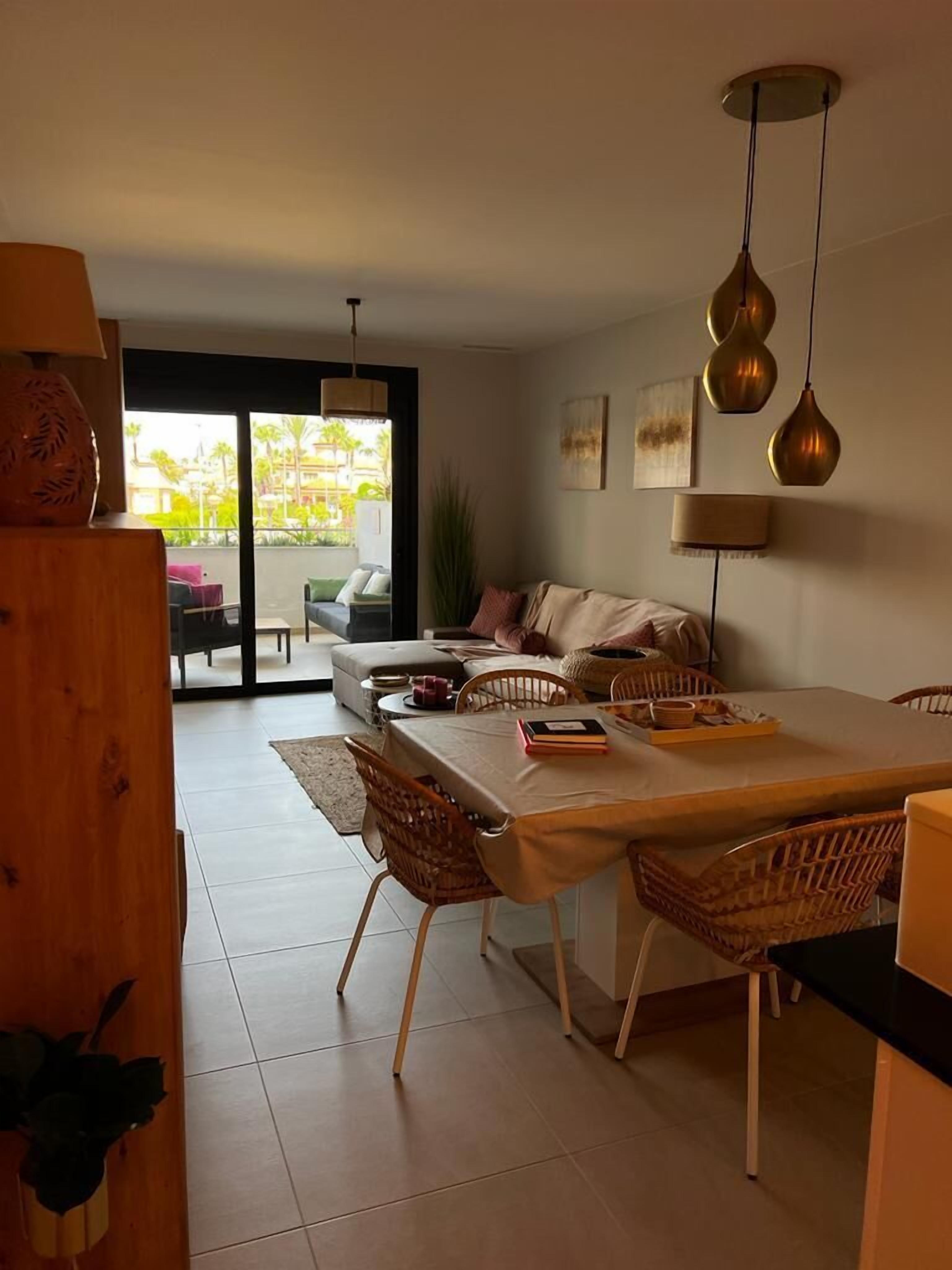 Una sala de estar moderna con comedor, un conjunto de sofás y un ventanal con vistas al exterior.