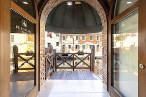 Vue depuis le balcon d’un hôtel Eurostars, avec une arche en briques, une balustrade en bois et un aperçu du paysage urbain.
