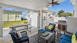 A covered patio area with wicker furniture, a grill, and a sign reading "Beach Shack." - Free Golf Cart, Beach Access/w Parking, + 3 pools! (Surfside Beach)