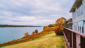 Une vue sur le lac, avec une terrasse en bois donnant sur l’étendue d’eau et les couleurs automnales des arbres.