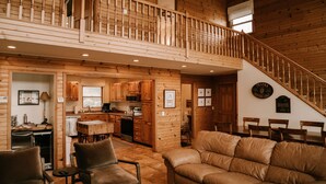 Un vaste espace de vie de style loft, doté d’un escalier en bois, d’un coin repas et d’une cuisine.