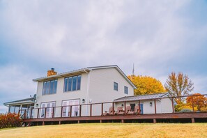 A two-story house with a porch and a small attached structure. - Secluded Ohio River Retreat Retreat with Hot Tub - Sleeps 10 (Elizabethtown)