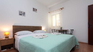 A neatly arranged bedroom with a bed, bedside table, and a small table with chairs. - ANTOLOVIC Studio with Terrace (Rovinj)
