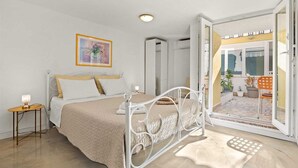 Un dormitorio con cama, mesita de noche y un cuadro en la pared.
