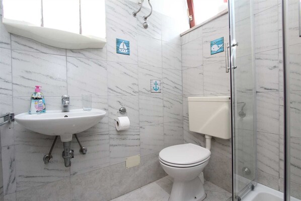 A bathroom with a white sink, toilet, and glass shower enclosure. - MIRIANA Studio with Balcony (Rovinj)