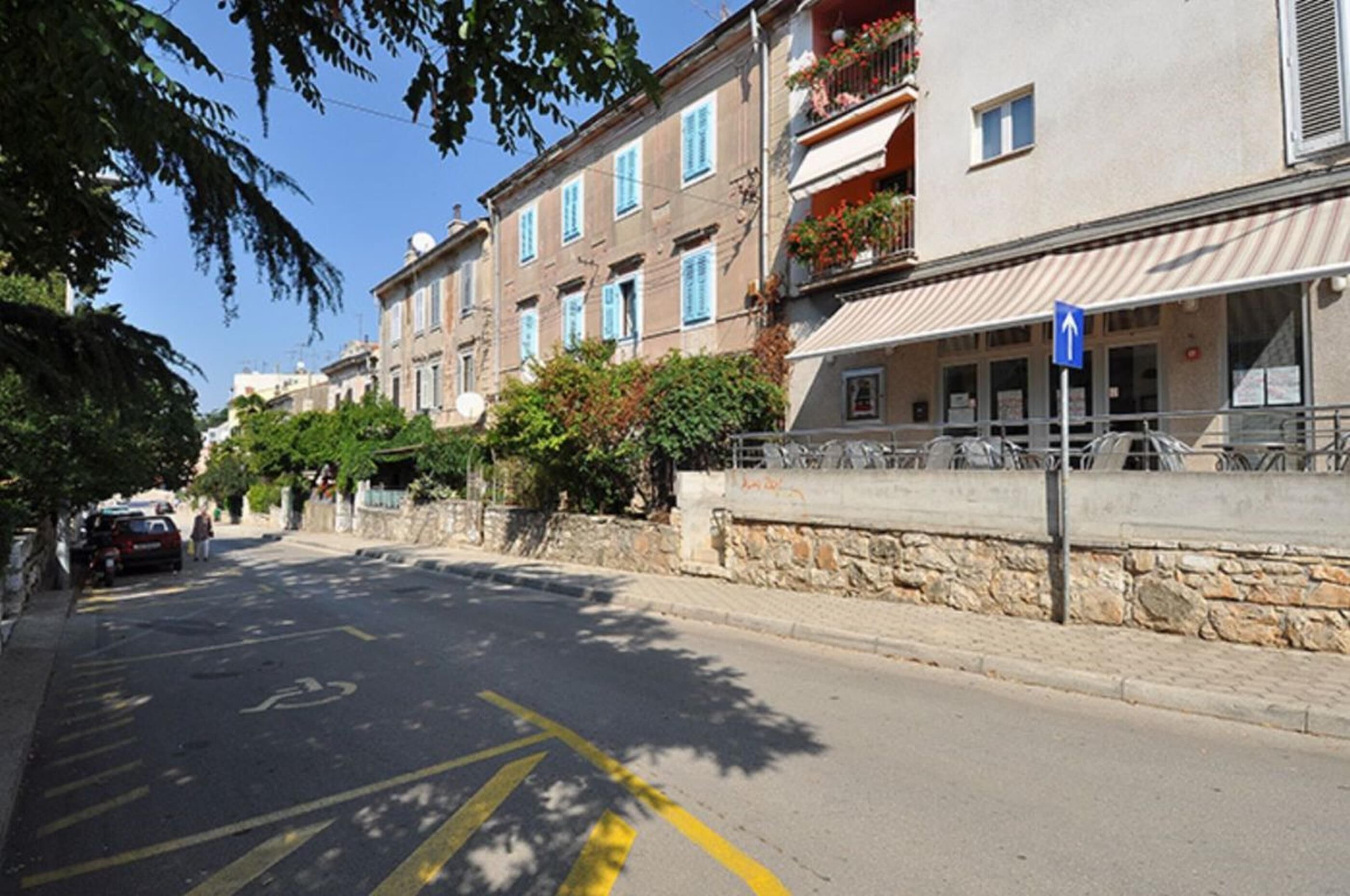 Una calle con una hilera de edificios, una zona de aparcamiento para bicicletas y un cielo azul despejado.