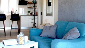 En moderne stue med en blå sofa, et hvidt sofabord og en unik, rund lampe.