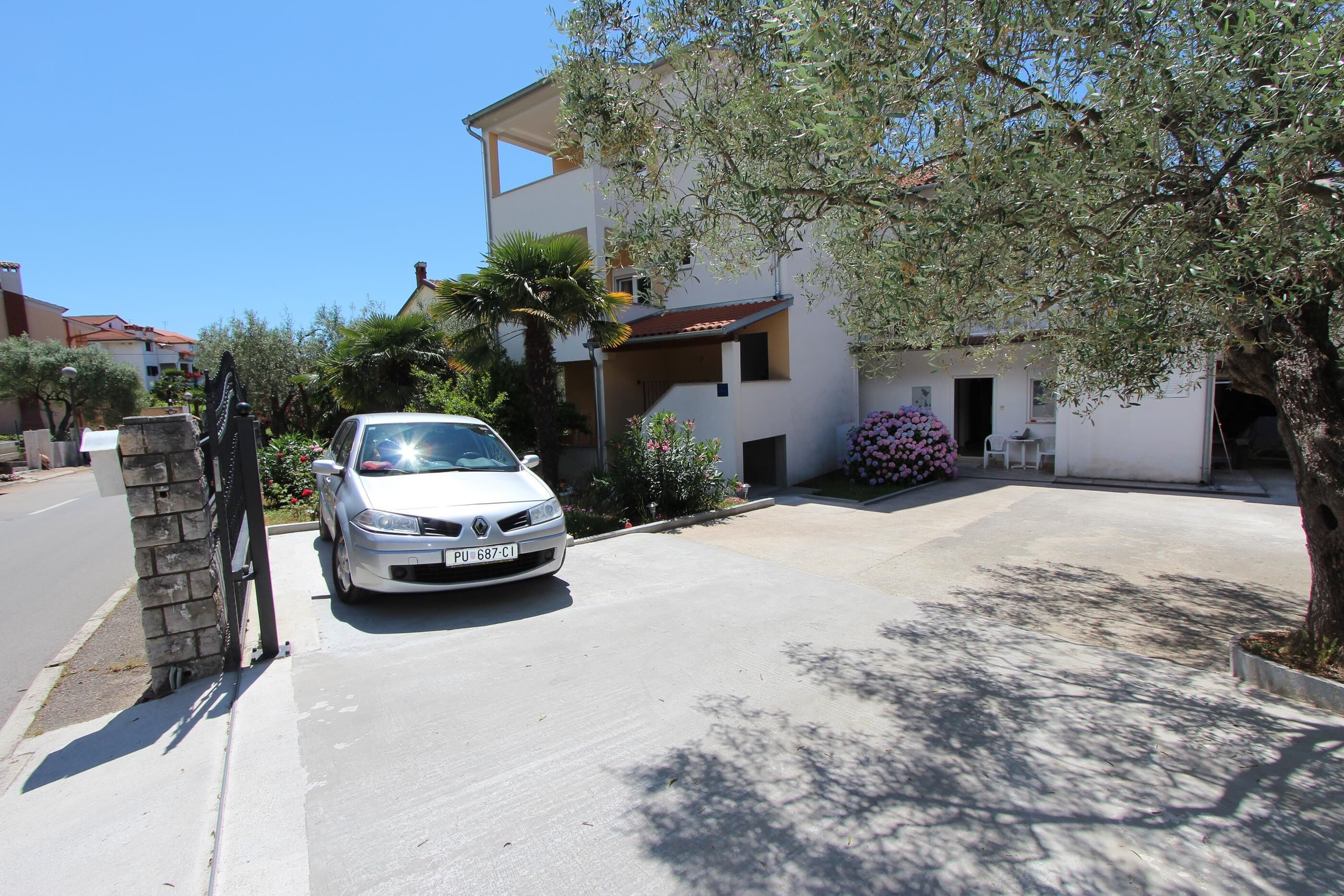 Una casa moderna de dos pisos con un coche estacionado en la entrada.
