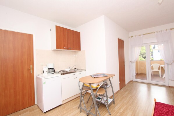 A compact kitchen with a coffee maker, a sink, and a small table with a chair. - SENA Studio with Balcony 3 (Rovinj)