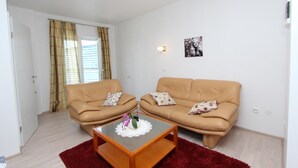 A living room with two beige sofas, a glass coffee table, and a red rug. - SALLY Comfort Studio 6 (Rovinj)