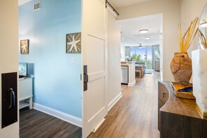 Stroll through the hotel corridor to a fully equipped kitchen area with a sink and window offering a view of the outdoors.