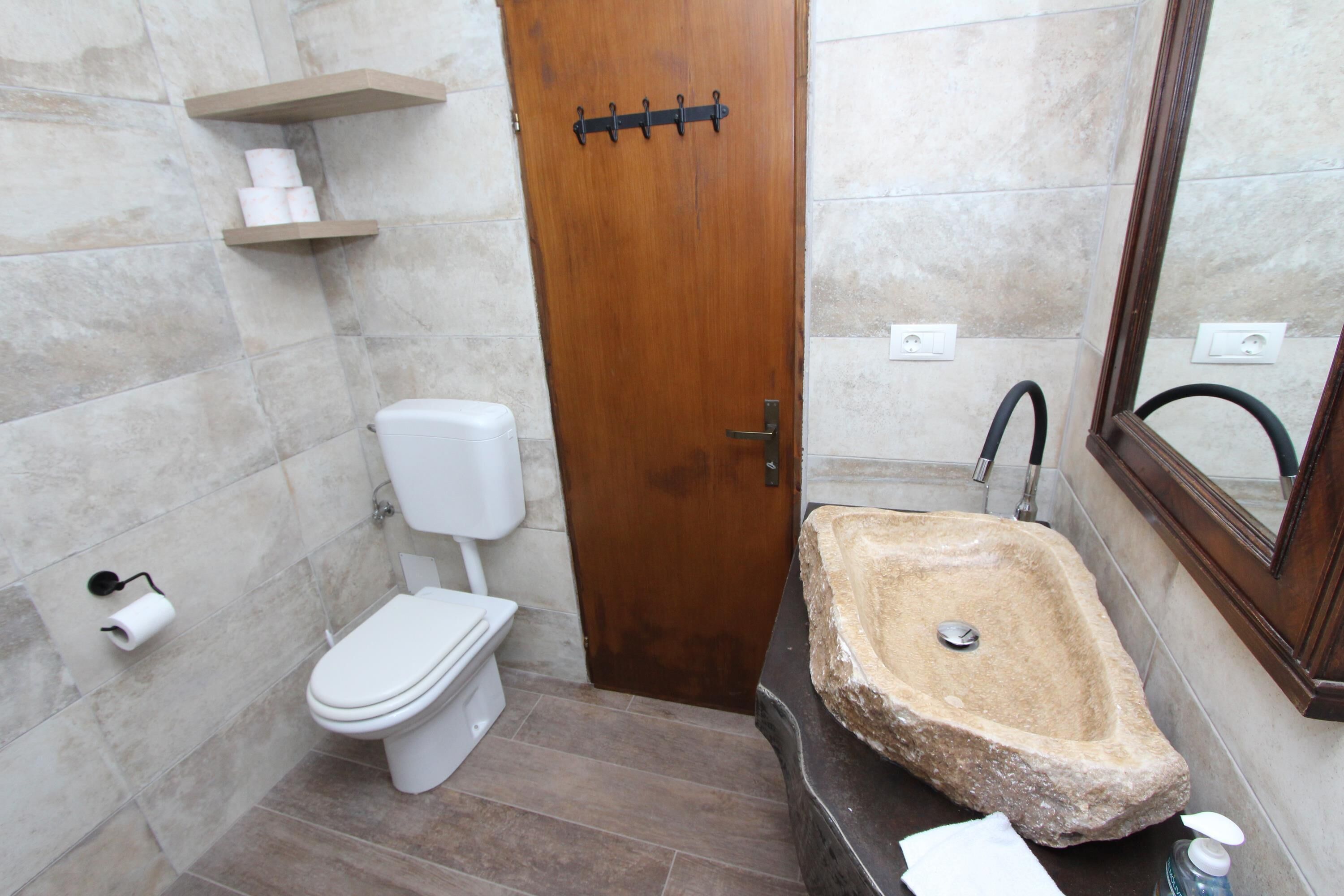 Une salle de bain avec des toilettes, un lavabo et un miroir.