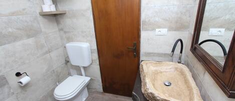 Une salle de bain avec des toilettes, un lavabo et un miroir.