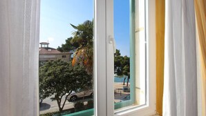 A window with a view of a building with a tiled roof, a tree, and a parked car. - VILLA ROSSELLA 2 Studio (Eufemia) (Rovinj)
