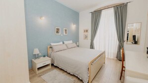 A bedroom with a bed, nightstand, lamp, and a mirror. - VILLA ROSSELLA 2 Studio (Cardaria) (Rovinj)
