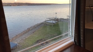 A view of a lake with a dock and a grassy area in the foreground.