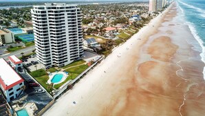 Un hotel de gran altura con varios pisos, una piscina y ubicación frente a la playa.
