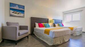 Habitación de hotel con dos camas, una silla, una mesita de noche y un cuadro con una escena de playa.