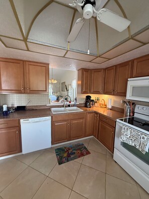 A kitchen with wooden cabinets, a dishwasher, a microwave, and a stove.