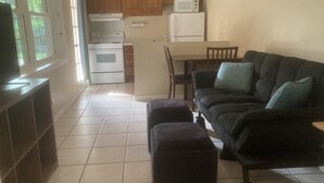 Een compact verblijf met een kitchenette, een bank, een eettafel en een televisie.