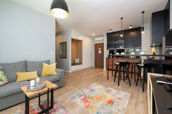Un salon moderne avec un canapé, une table basse et un tapis coloré.