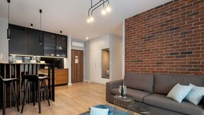 Un espacio habitable moderno con cocina, comedor y una zona de estar acogedora con sofá y mesa de centro.