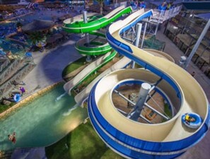 Een waterpark met meerdere glijbanen en een centraal gelegen rond zwembad.