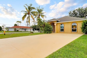 A single-story house with a red roof, a number 801 garage, and a well-maintained lawn.