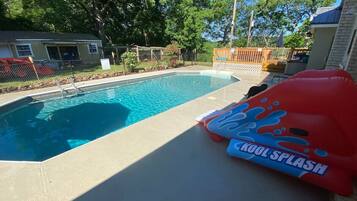 Relax by the pool surrounded by lush gardens and a deck.